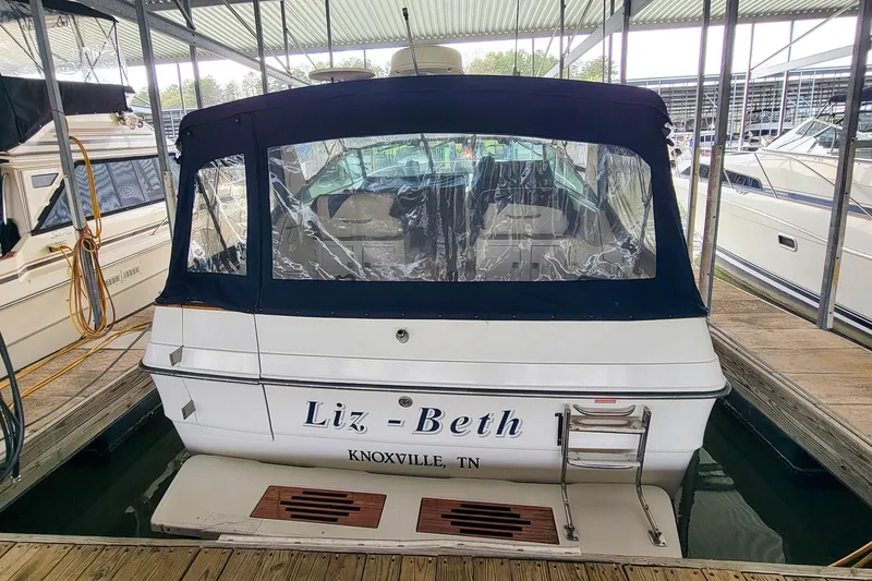Slide: The Image of 1987 Sea Ray 340 Express Cruiser docked, rear view with canopy, named "Liz-Beth". - 6