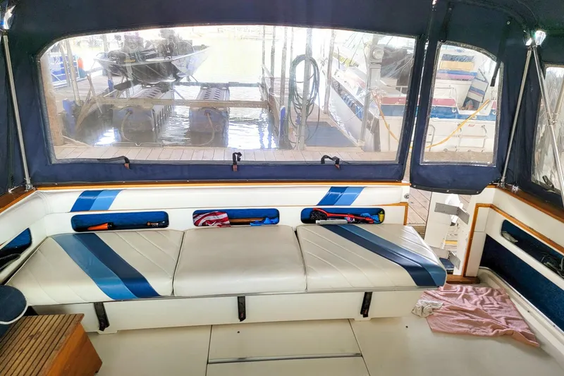 Slide: The Image of 1987 Sea Ray 340 Express Cruiser interior with blue and white seating, dock view. - 7