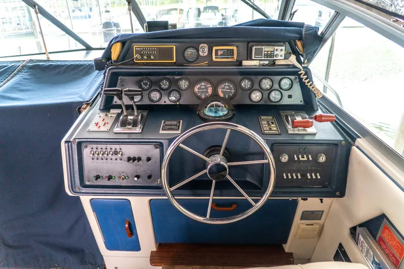 Slide: The Image of 1987 Sea Ray 340 Express Cruiser helm with gauges, controls, and steering wheel. - 9