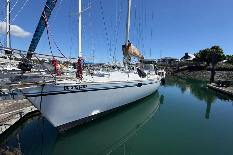 The Image of 1990 Beneteau Oceanis 500 sailboat docked in a marina under clear blue skies. - 1