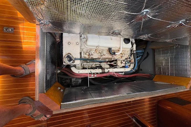 Slide: The Image of Engine compartment of 1990 Beneteau Oceanis 500 sailboat with insulation and visible components. - 102