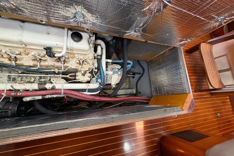 Slide: The Image of Engine compartment of 1990 Beneteau Oceanis 500 sailboat, showcasing mechanical components and insulation. - 103