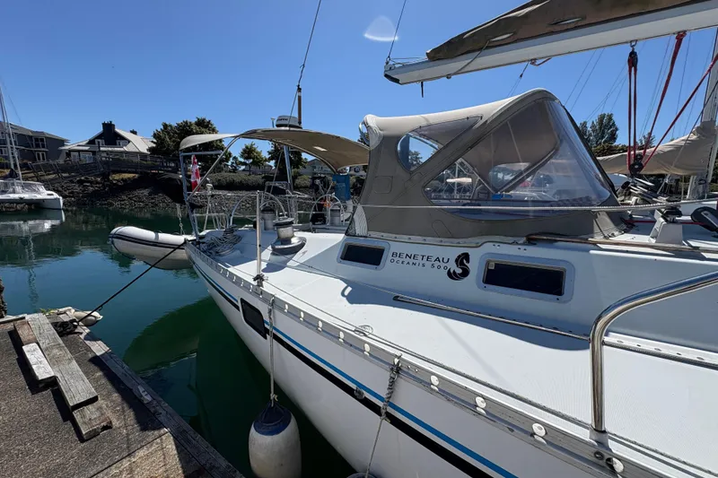 Slide: The Image of 1990 Beneteau Oceanis 500 sailboat docked in a marina under clear blue skies. - 16