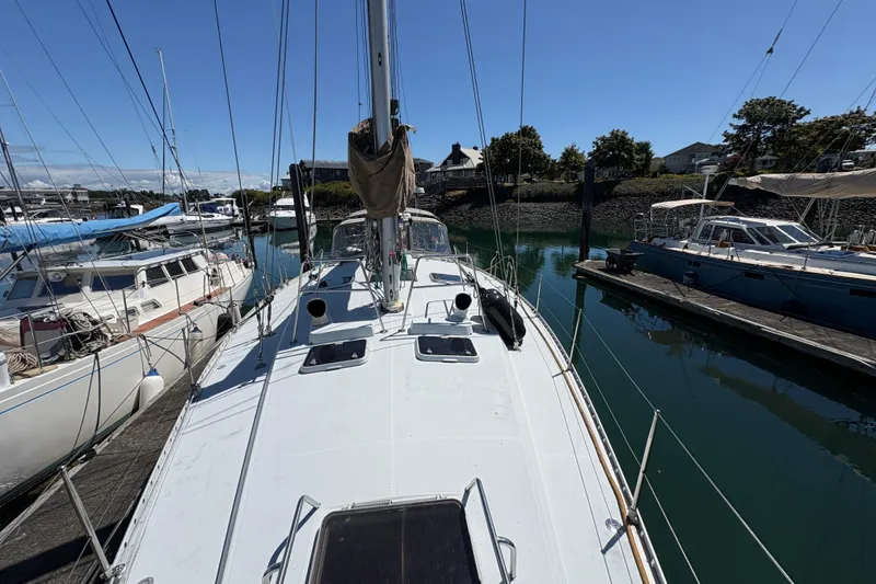 Slide: The Image of 1990 Beneteau Oceanis 500 sailboat docked in a marina under clear blue skies. - 24