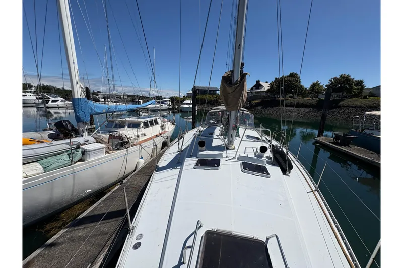 Slide: The Image of 1990 Beneteau Oceanis 500 sailboat docked in a marina under clear blue skies. - 25