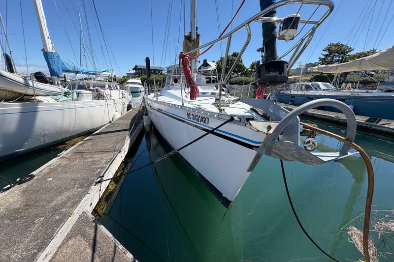 Slide: The Image of 1990 Beneteau Oceanis 500 sailboat docked in a marina under clear blue skies. - 4