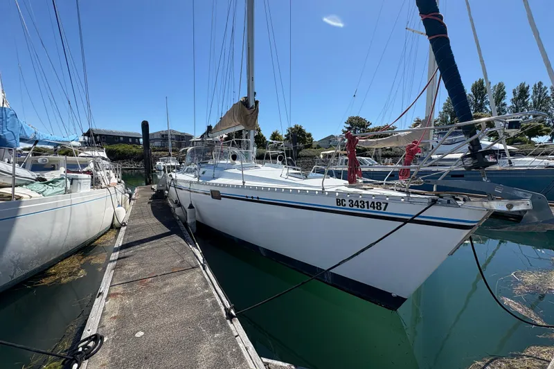 Slide: The Image of 1990 Beneteau Oceanis 500 sailboat docked in a marina under clear blue skies. - 5