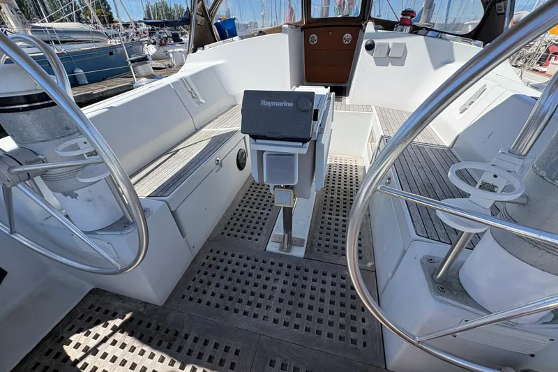 Slide: The Image of 1990 Beneteau Oceanis 500 yacht cockpit with dual steering wheels and Raymarine equipment. - 50