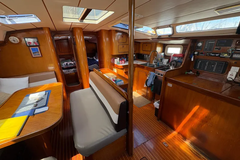 Slide: The Image of Interior of 1990 Beneteau Oceanis 500 sailboat, featuring cozy dining and kitchen area. - 57