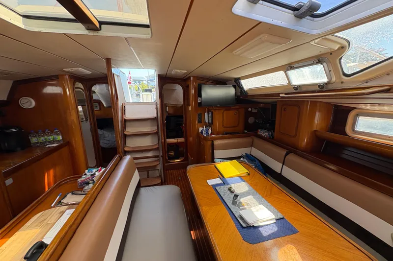 Slide: The Image of Interior of 1990 Beneteau Oceanis 500 sailboat, featuring wood finishes and seating area. - 61