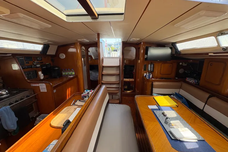 Slide: The Image of Interior of 1990 Beneteau Oceanis 500 sailboat with cozy seating and wooden finishes. - 62