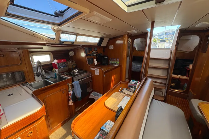 Slide: The Image of Interior of 1990 Beneteau Oceanis 500 sailboat with kitchen and seating area. - 64