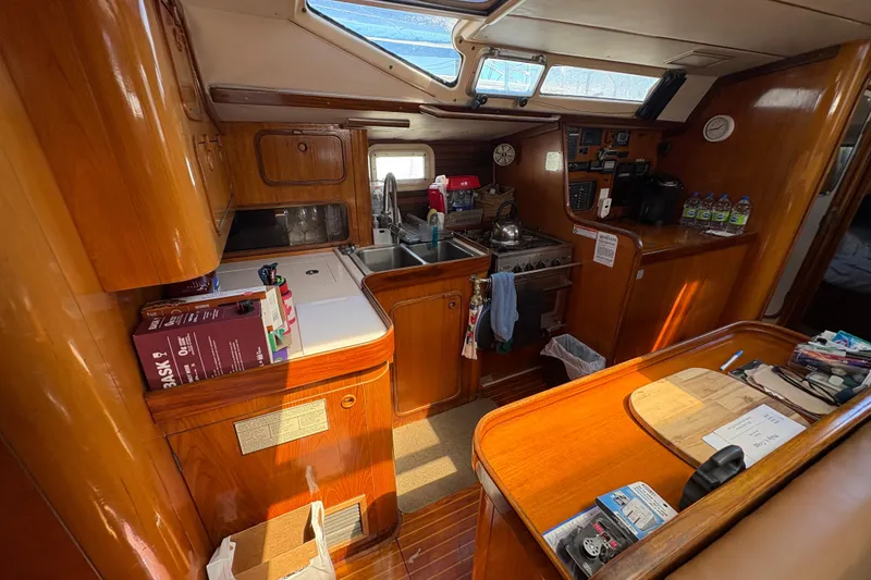 Slide: The Image of Interior of 1990 Beneteau Oceanis 500 yacht with wooden cabinetry and kitchen amenities. - 65
