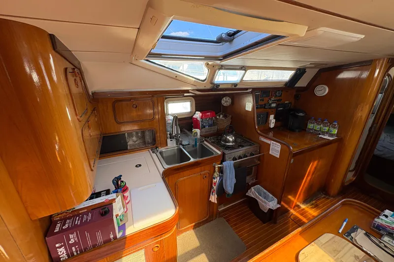 Slide: The Image of Interior of 1990 Beneteau Oceanis 500 yacht kitchen with wooden cabinetry and skylight. - 66