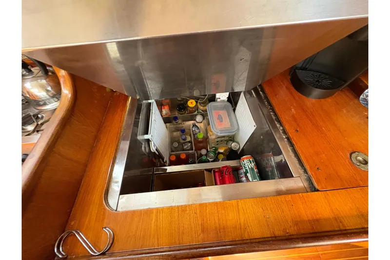 Slide: The Image of Interior view of Beneteau Oceanis 500 yacht's kitchen storage, featuring beverages and containers. - 72