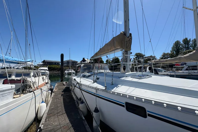 Slide: The Image of 1990 Beneteau Oceanis 500 sailboat docked at marina under clear blue sky. - 8