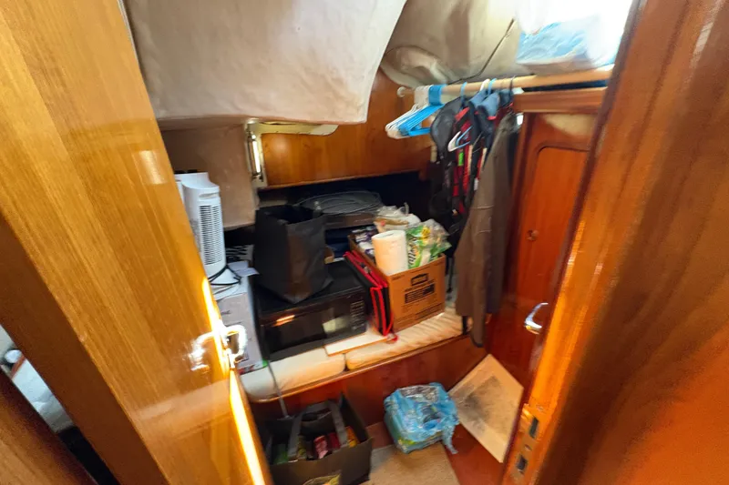 Slide: The Image of Interior of 1990 Beneteau Oceanis 500 sailboat with storage and hanging clothes. - 89
