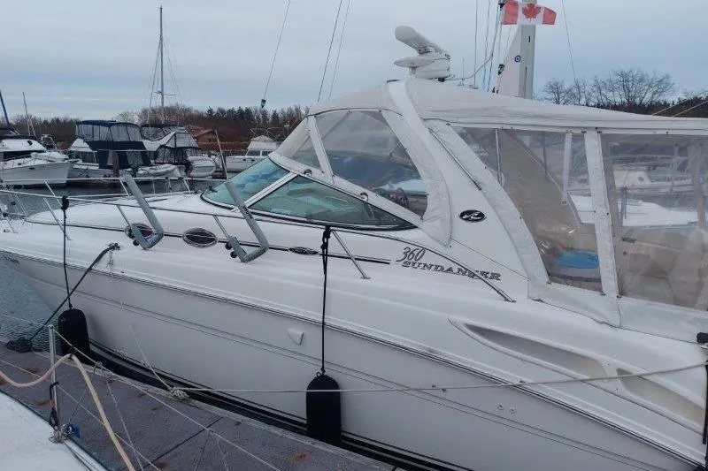 Slide: The Image of 2003 Sea Ray 360 Sundancer docked at marina, side view with clear canopy. - 10