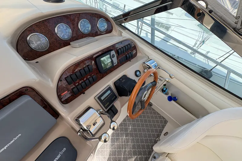 Slide: The Image of 2003 Sea Ray 360 Sundancer helm with wood accents and modern controls. - 17