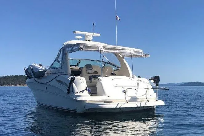 Slide: The Image of 2003 Sea Ray 360 Sundancer boat on calm blue water under clear sky. - 2