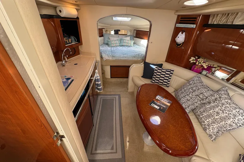 Slide: The Image of 2003 Sea Ray 360 Sundancer interior with kitchenette, seating area, and cozy bedroom. - 24