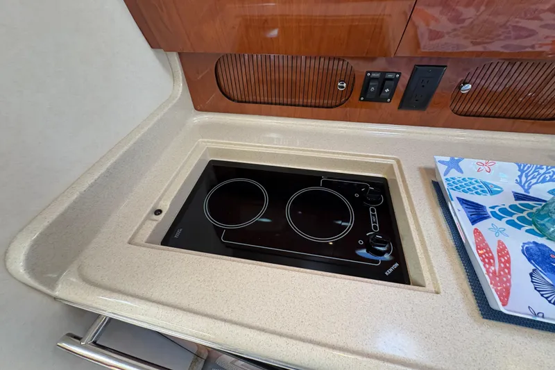 Slide: The Image of 2003 Sea Ray 360 Sundancer kitchen with electric stove and colorful fish-themed decor. - 42