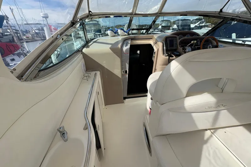 Slide: The Image of 2003 Sea Ray 360 Sundancer cockpit with helm, seating, and marina view. - 47