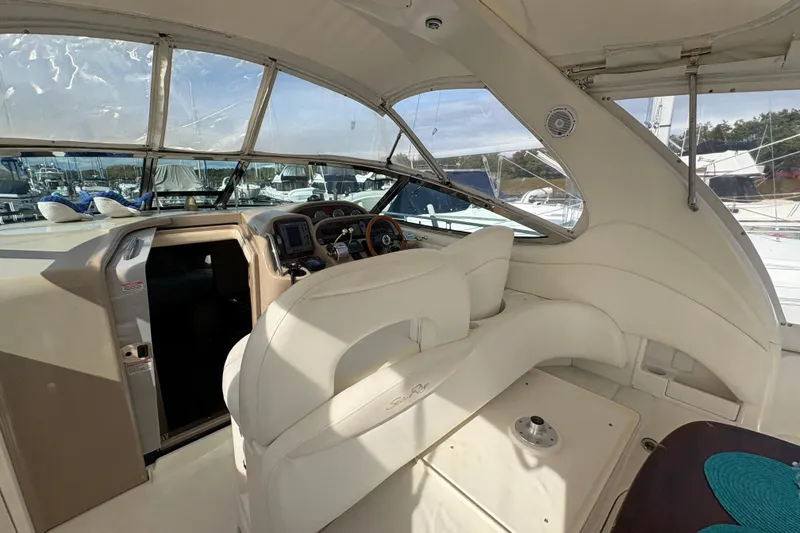Slide: The Image of 2003 Sea Ray 360 Sundancer cockpit with helm, white seating, and panoramic windows. - 48