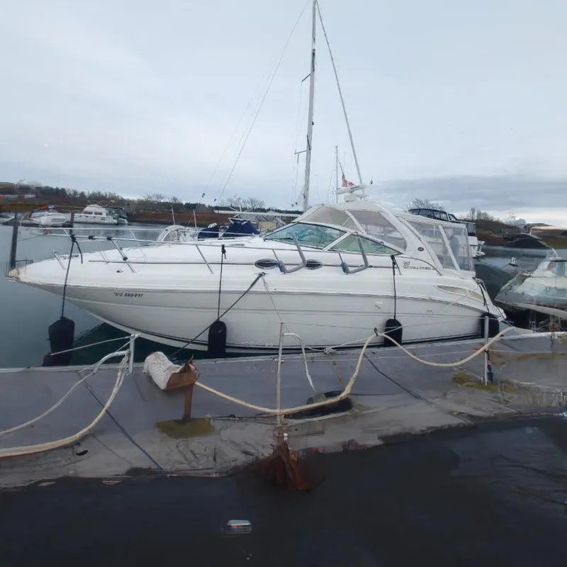 Slide: The Image of 2003 Sea Ray 360 Sundancer yacht docked in a marina, overcast sky. - 5