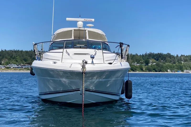 Slide: The Image of 2003 Sea Ray 360 Sundancer yacht anchored on calm water with scenic shoreline backdrop. - 67