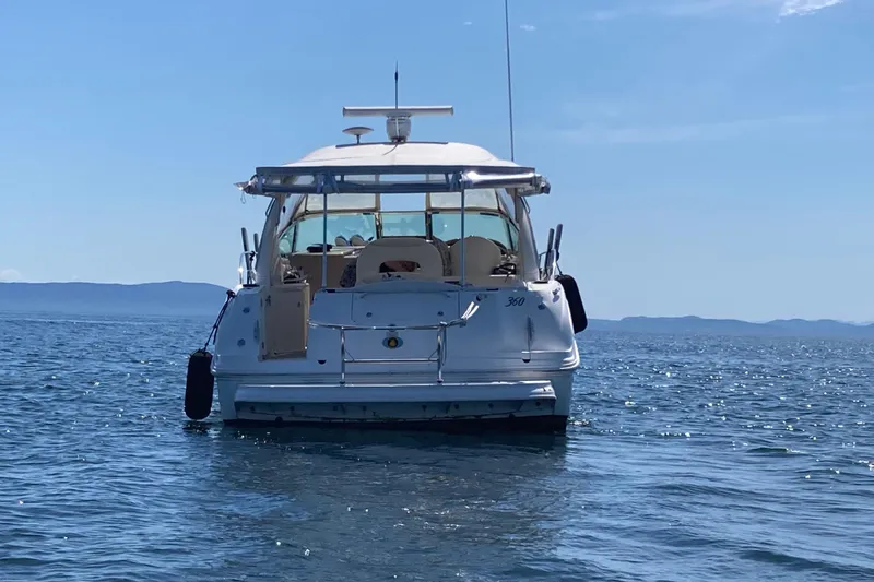 Slide: The Image of 2003 Sea Ray 360 Sundancer yacht on calm ocean waters under clear blue sky. - 69