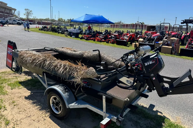 Slide: The Image of 2026 Gator Tail PREDATOR 1448 boat on trailer, outdoor display with equipment in background. - 2