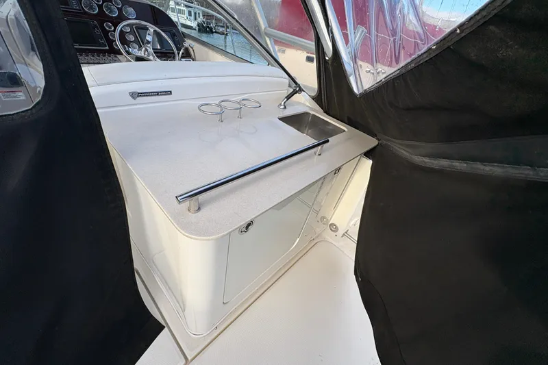 Slide: The Image of 2009 Sea Ray 290 Amberjack cockpit with steering wheel and sink area. - 36