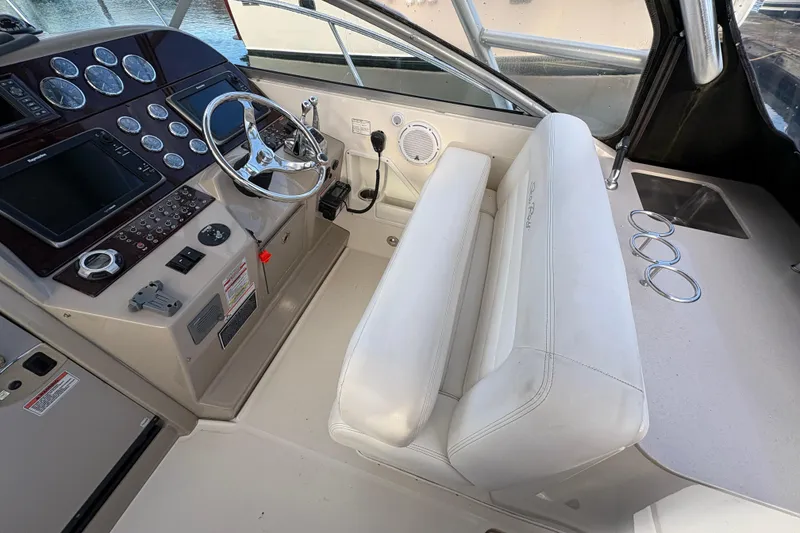 Slide: The Image of 2009 Sea Ray 290 Amberjack helm with steering wheel, gauges, and white seating. - 46