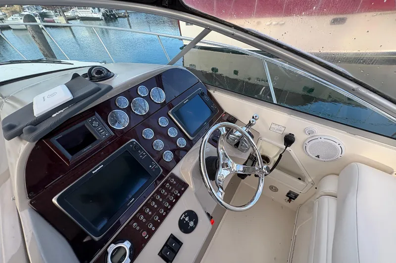 Slide: The Image of 2009 Sea Ray 290 Amberjack helm with gauges, steering wheel, and navigation screens. - 48