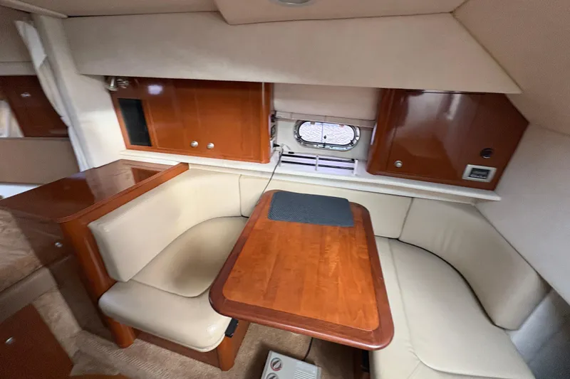 Slide: The Image of 2009 Sea Ray 290 Amberjack cabin interior with wooden table and beige seating. - 63