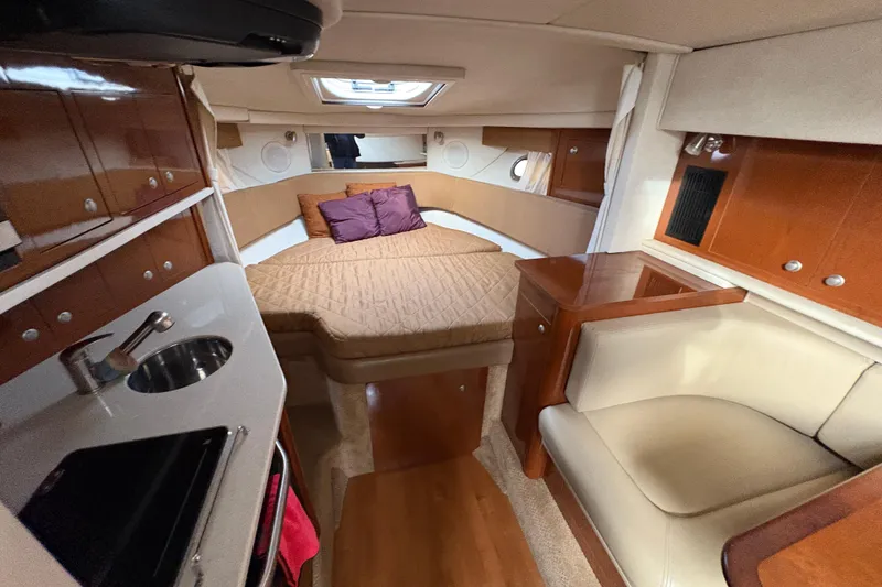 Slide: The Image of 2009 Sea Ray 290 Amberjack cabin interior with bed, seating, and kitchenette. - 66