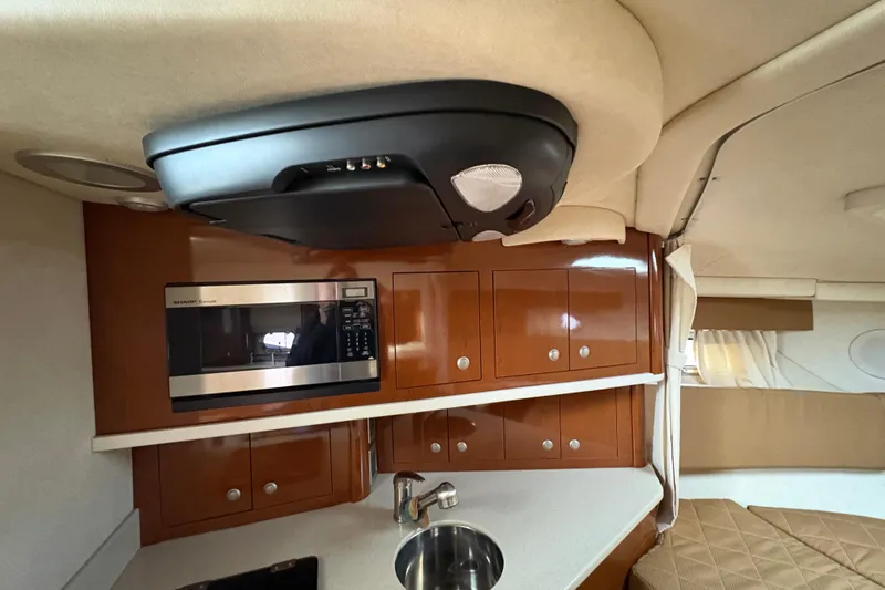 Slide: The Image of 2009 Sea Ray 290 Amberjack interior with microwave, cabinets, and sink in cabin. - 74