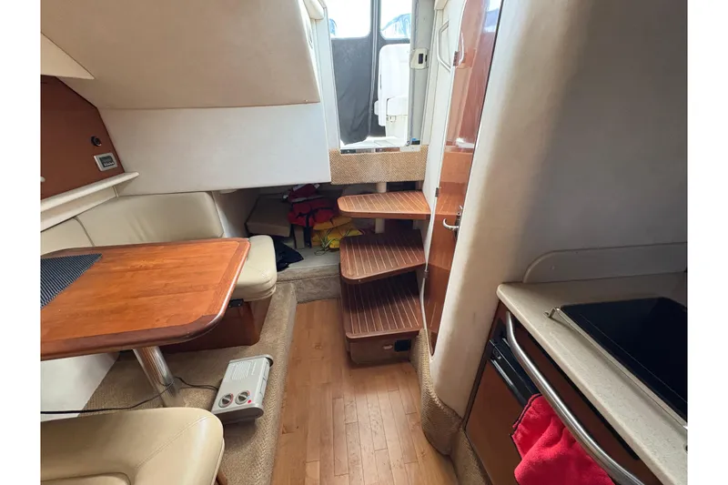 Slide: The Image of Interior of 2009 Sea Ray 290 Amberjack boat with wooden table and compact kitchen. - 75