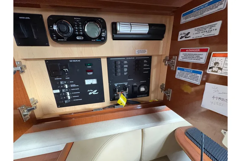 Slide: The Image of 2009 Sea Ray 290 Amberjack control panel with Sony audio system and safety notices. - 78
