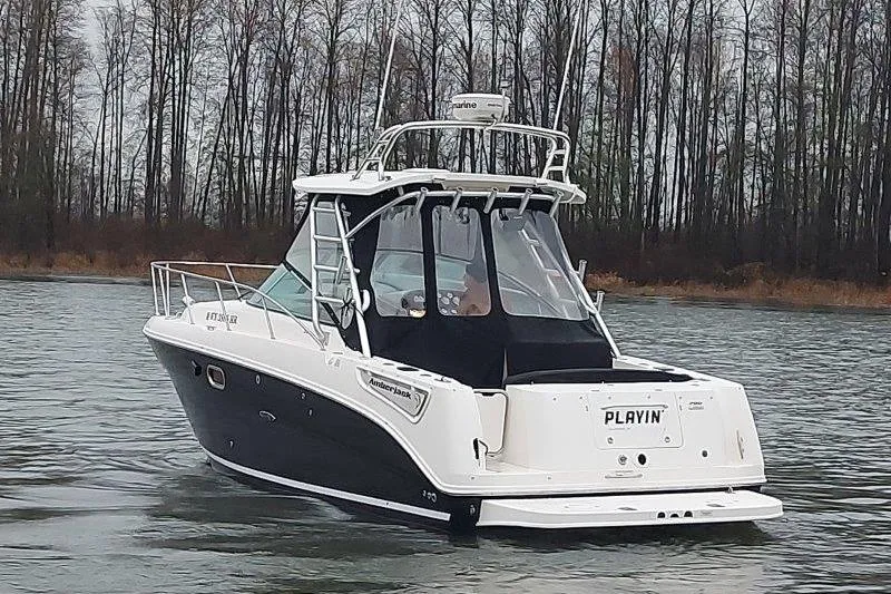 Slide: The Image of 2009 Sea Ray 290 Amberjack boat on calm water, surrounded by trees. - 9