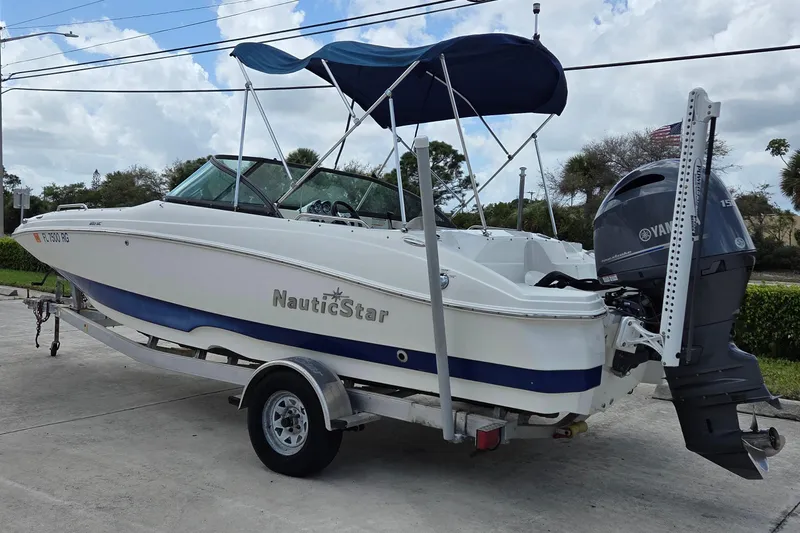 Slide: The Image of 2017 NauticStar 203DC Sport Deck boat on trailer with Yamaha outboard motor. - 2