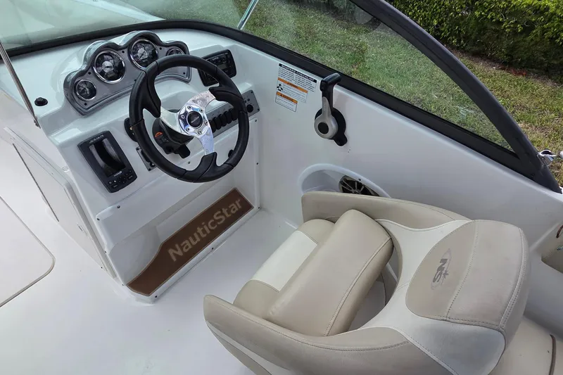 Slide: The Image of 2017 NauticStar 203DC Sport Deck boat interior with steering wheel and dashboard controls. - 4