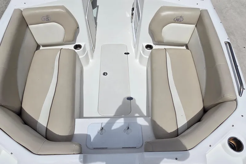 Slide: The Image of 2017 NauticStar 203DC Sport Deck boat interior with beige seating and cup holders. - 6