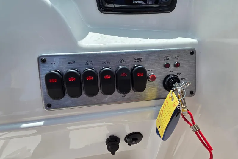 Slide: The Image of Control panel of a 2017 NauticStar 203DC Sport Deck boat with switches and ignition. - 9