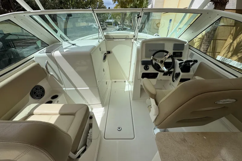 Slide: The Image of 2018 Sailfish 275 DC boat interior with beige seating and modern dashboard. - 12