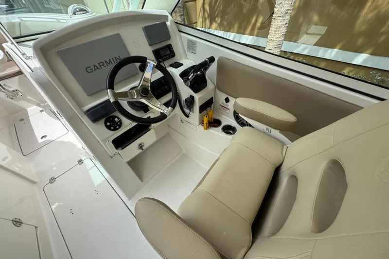 Slide: The Image of 2018 Sailfish 275 DC boat cockpit with Garmin navigation system and beige seating. - 17