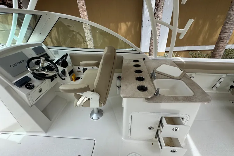Slide: The Image of 2018 Sailfish 275 DC boat interior with cushioned seating and table. - 23