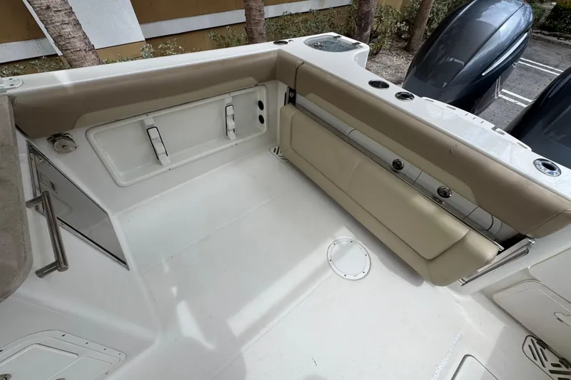 Slide: The Image of 2018 Sailfish 275 DC boat interior with beige seating and storage compartments. - 6