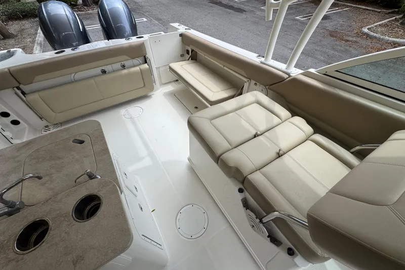 Slide: The Image of 2018 Sailfish 275 DC boat interior with beige seating and dual outboard motors. - 9